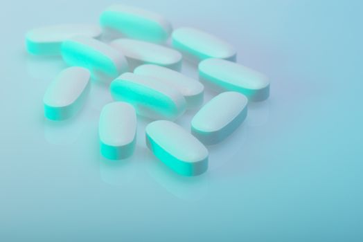 Drug, medicine or supplement pills on table with color effects. Health concept. Medical background.