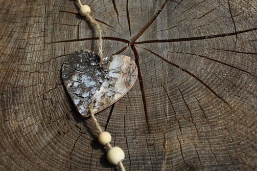 The picture shows a wooden heart on a tree trunk.