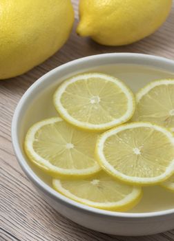 Lemon slices in a bowl with water. Close up view.