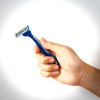 Right Asian male hand holding single disposable razor with blade isolated on white background. Blue plastic razor with clipping path and copy space
