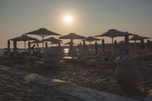 Sunbeds and umbrellas on Modica's beach at sunset