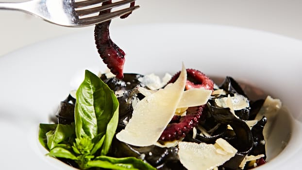 Pasta with black cuttlefish ink, octopuses and parmesan