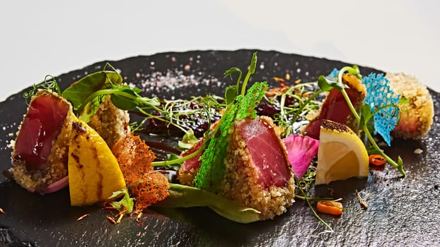 Close up of rare seared Ahi tuna slices with fresh vegetable salad on a plate. Shallow dof