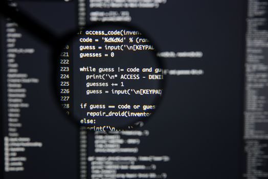Real Python code developing screen. Programing workflow abstract algorithm concept. Lines of Python code visible under magnifying lens.
