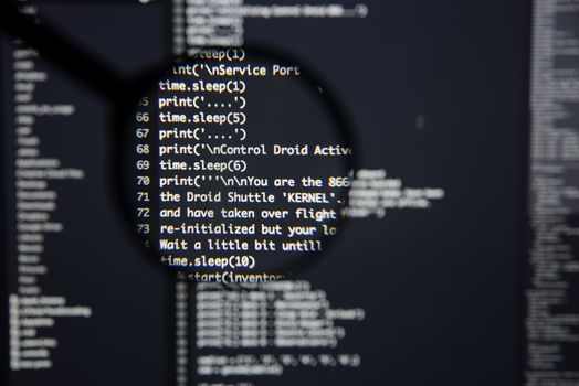 Real Python code developing screen. Programing workflow abstract algorithm concept. Lines of Python code visible under magnifying lens.
