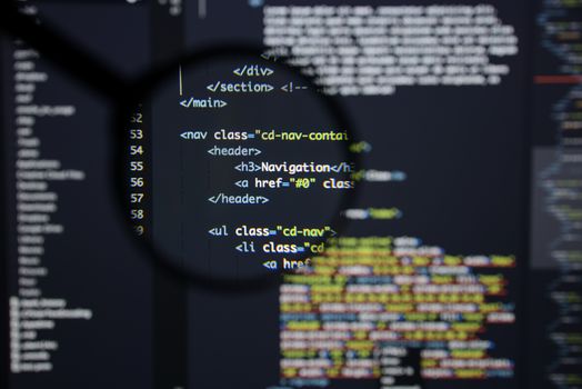 Real Html code developing screen. Programing workflow abstract algorithm concept. Lines of Html code visible under magnifying lens.