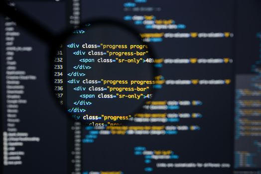 Real Html code developing screen. Programing workflow abstract algorithm concept. Lines of Html code visible under magnifying lens.