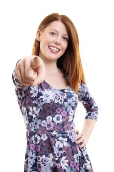 Beautiful fashionable young girl smiling and pointing a finger at you, isolated on white background.