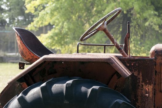 Close up view of an old, rusty, abandoned tractor.