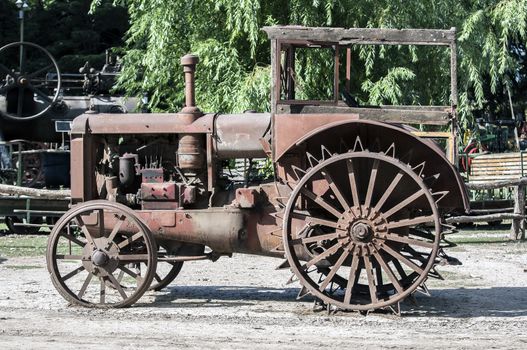 Close up view of an old, rusty, abandoned tractor.