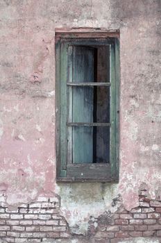 Stock image of an old window on exposed brick wall.