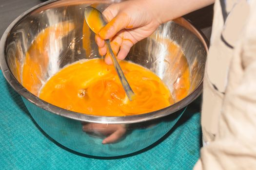 Little boy helps in the kitchen while baking cake.