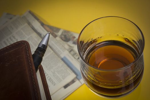 Glass with whiskey on a yellow background