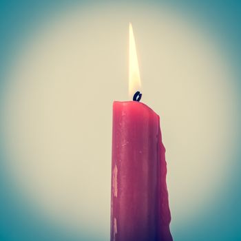 Vintage tone close-up single red burning candle isolated on white background. Popular Asian stick candle for daily and holiday uses.