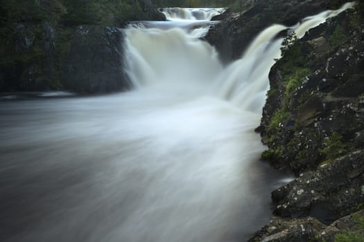 Waterfall close up in forest with stones and stream