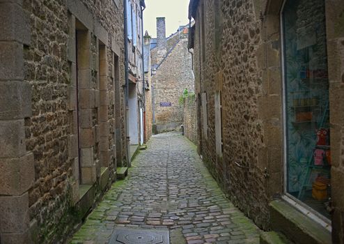 DINAN, FRANCE - April 7th 2019 - Old traditional narrow alley with houses made of stone in small french town