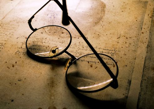 Close up of old classic spectacles on a book background