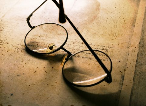 Close up of old classic spectacles on a book background