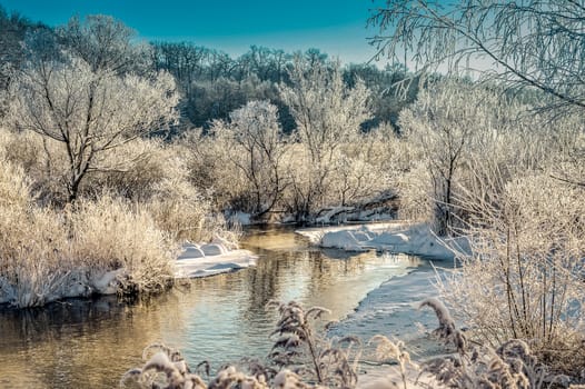 Winter sunny landscape with river and forest.