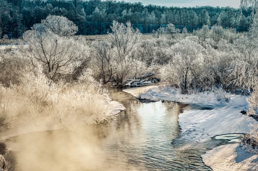 Winter sunny landscape with river and forest.