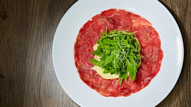 Meat carpaccio with salad. Shallow dof