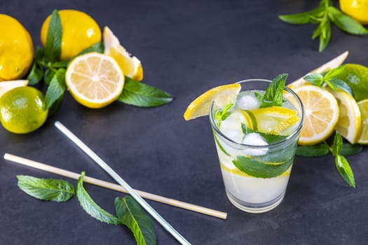 Top view of fresh lemonade with mint and ice in glasses on black background. Focus on ice.