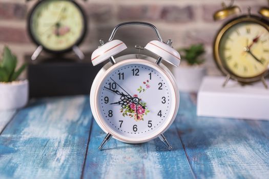 Vintage background with retro alarm clock on table. Focus on first clock.