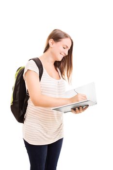 One second, let me just take this note down. Smiling female student with a backpack standing and writing in a notebook, isolated on white background.