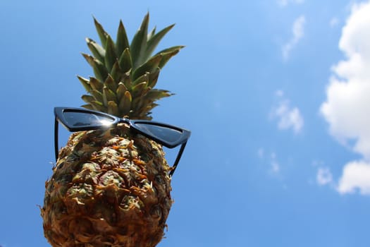The picture shows a funny pineapple with sunglasses.