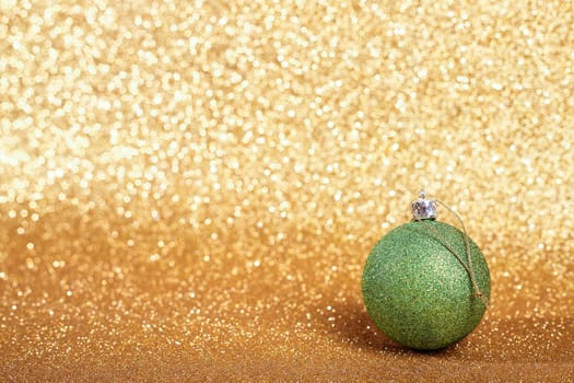 Christmas ball on abstract gold glitters bokeh background