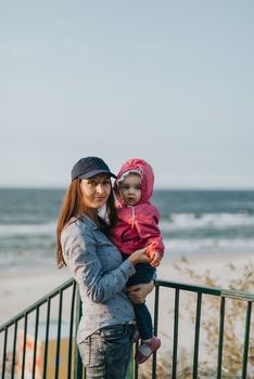 Mother and little daughter playing on the beach. Authentic image.