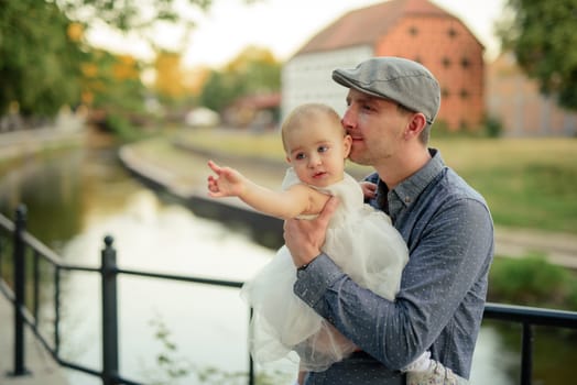 Happy loving family. Father and his daughter child girl playing and hugging outdoors. Cute little girl hugs daddy. Concept of Father's day. Authentic image.