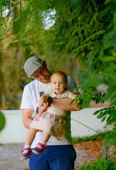 Happy loving family. Father and his daughter child girl playing and hugging outdoors. Cute little girl hugs daddy. Concept of Father's day. Authentic image.
