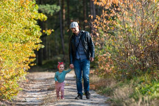 Happy loving family. Father and his daughter child girl playing and hugging outdoors. Cute little girl hugs daddy. Concept of Father's day. Authentic image.