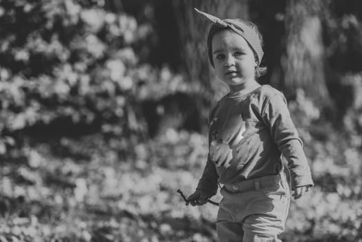 Adorable girl having fun on beautiful autumn day. authentic childhood image. black and white