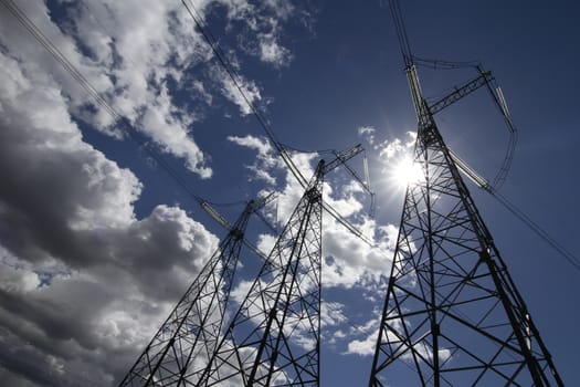 wide angle view of high voltage power pylons on against sky