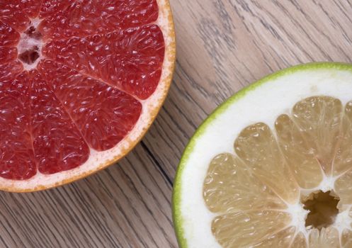 Green Sweetie or Pomelit and Red Grapefruit on wooden background. Top view.