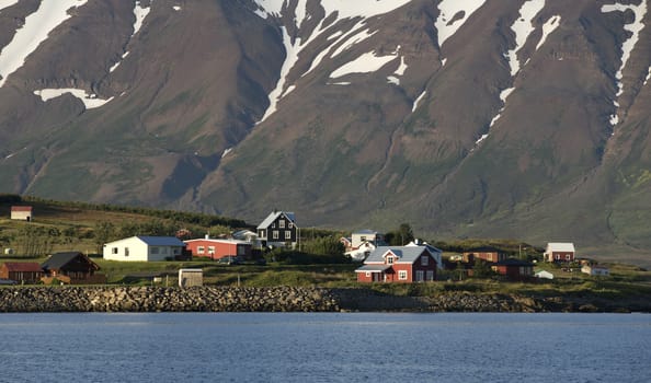 Typical icelandic landscape with volcanoes and houses.