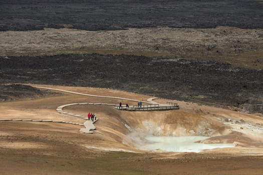 Tourists Walking on Geothermal Area and a Lake in the Volcano Crater in the Krafla Volcanic Region Iceland
