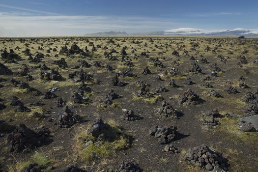 Icelandic Landscape with piles of stones and Mountains on background