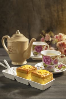 hot tea and sweet cake over wooden table