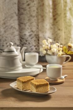 hot tea and sweet cake over wooden table