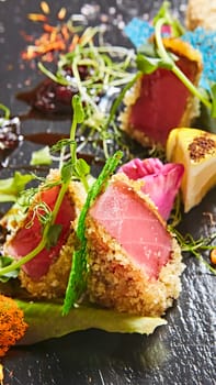 Close up of rare seared Ahi tuna slices with fresh vegetable salad on a plate. Shallow dof