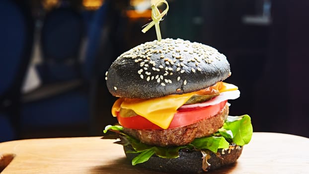 Japanese Black Burger with Cheese. Cheeseburger from Japan with black bun on dark background