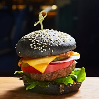 Japanese Black Burger with Cheese. Cheeseburger from Japan with black bun on dark background