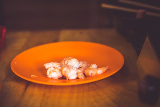 The Raw whole fresh uncooked prawns shrimps on stone red plate