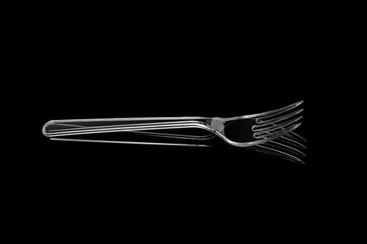 Transparent plastic fork isolated on black background. With clipping path