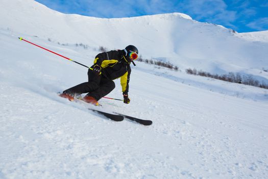 Skier in mountains, prepared piste and sunny day