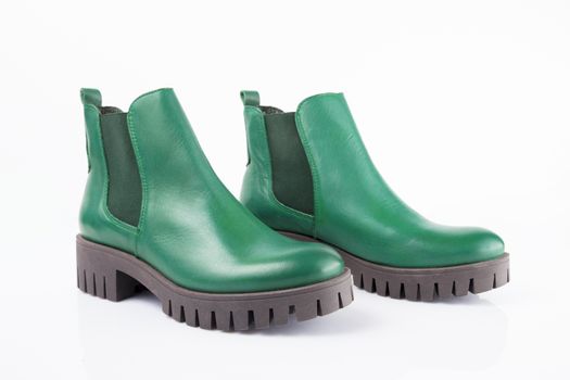 Female green leather boots on white background, isolated product.