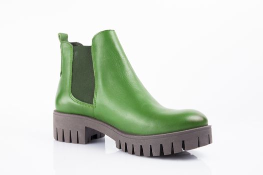 Female green leather boots on white background, isolated product.